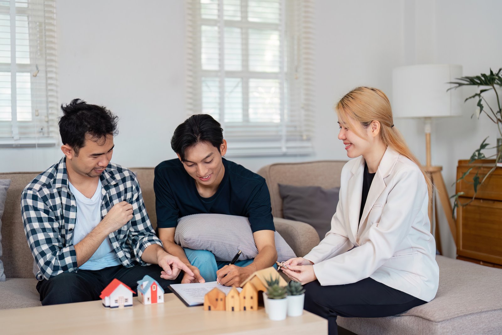 Listing agent reviewing multiple offers with home sellers at kitchen table