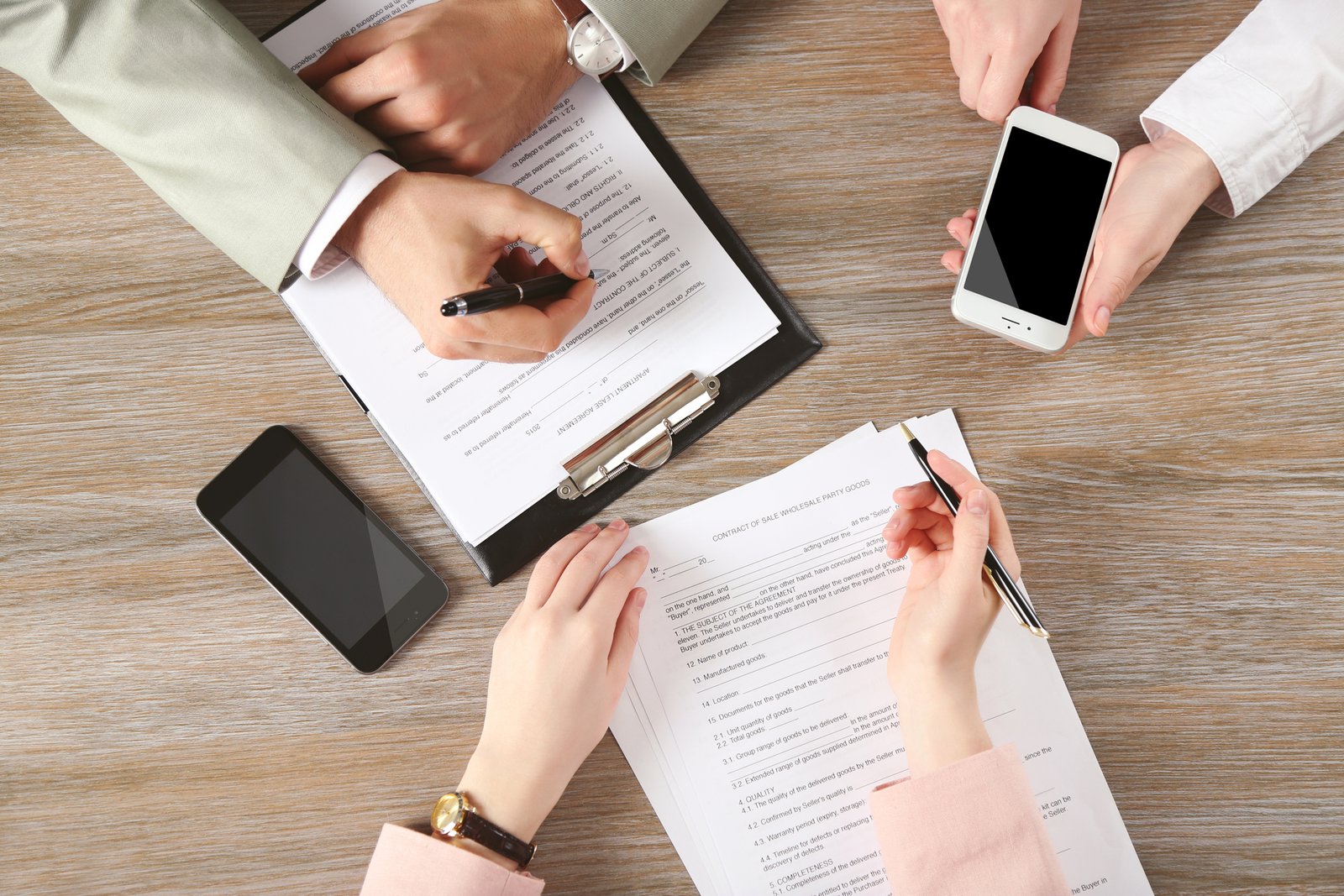Realtor reviewing a buyer representation agreement with clients at an office table