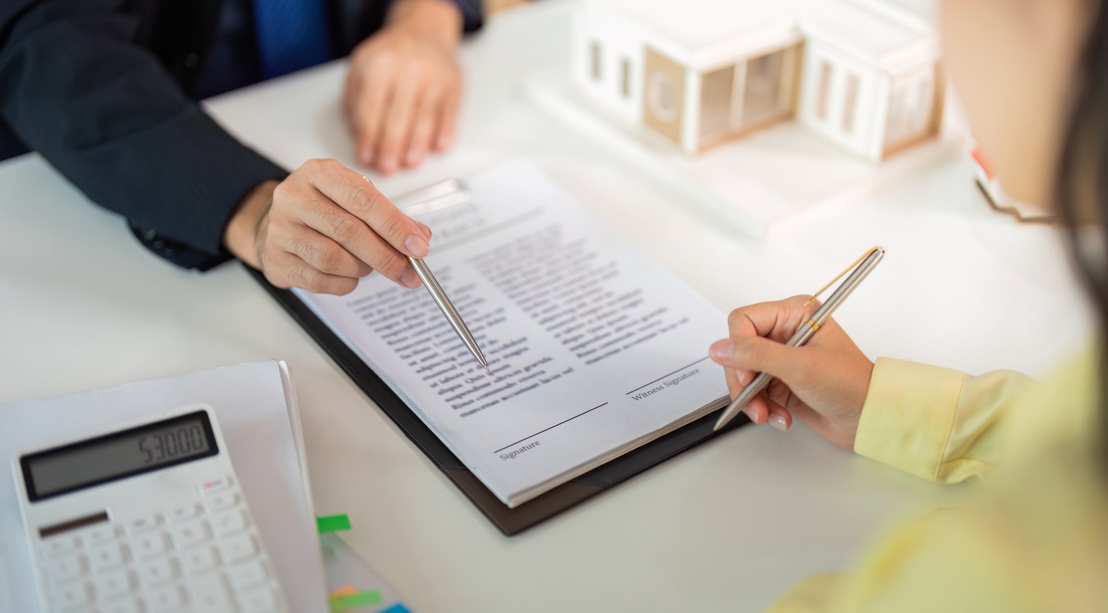 Realtor reviewing buyer representation agreement with first-time buyers